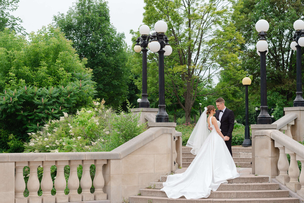 a full length portrait of a bride and groom on the terrace stairs of the Chateau Laurier.  Ottawa wedding photographer by JEMMAN Photography