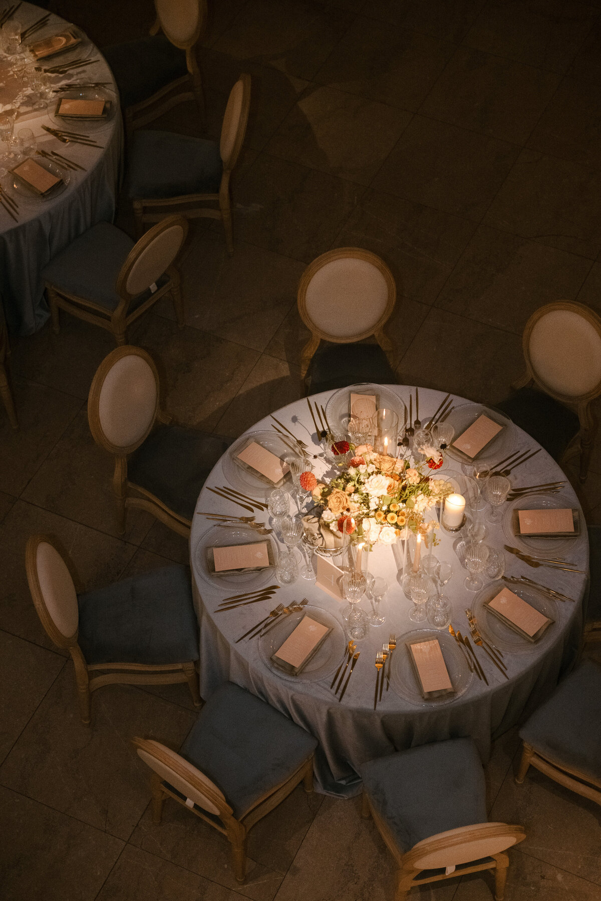 A table at a wedding reception, from above, with candles and a colourful centrepiece at Theatre St James.