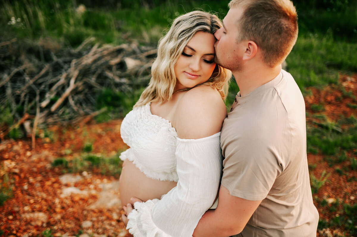 Joplin MO maternity photographer captures husband kissing pregnant mom forehead