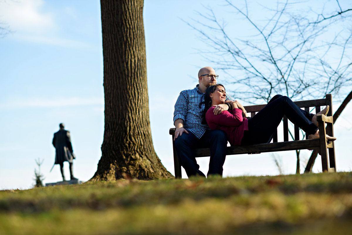 A couple lay on a bench in valley forge state park.