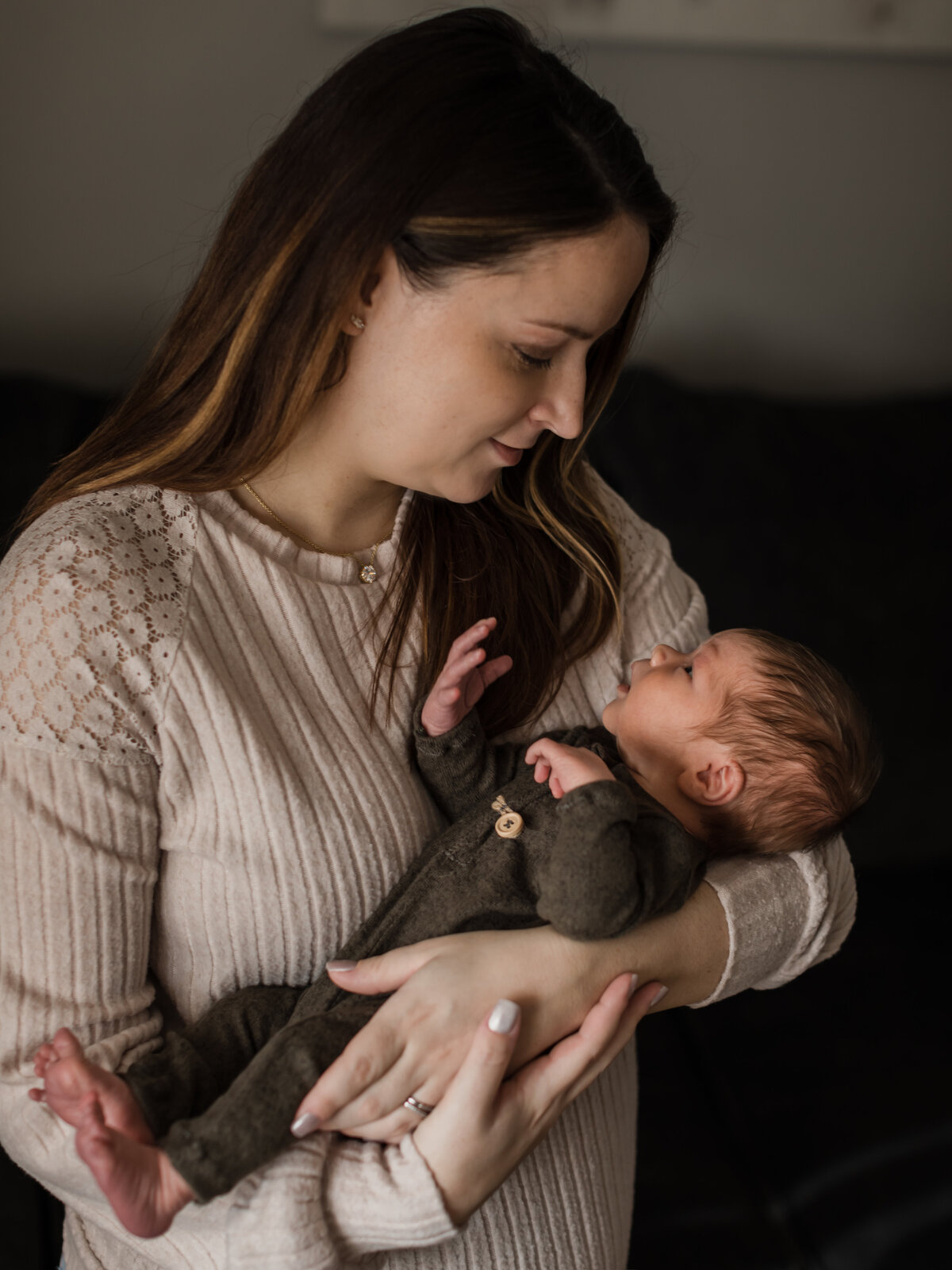 mom holding newborn baby son for in home lifestyle photography session