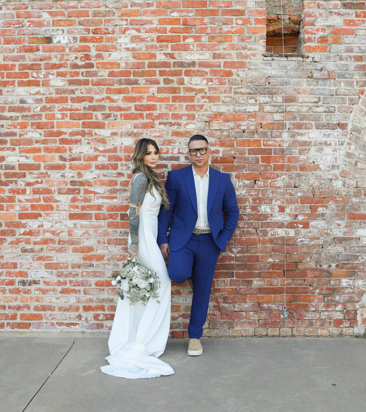 tattooed bride and groom standing against brick at The Bibb Mill by Columbus Georgia elopement photographer Amanda Richardson Photography