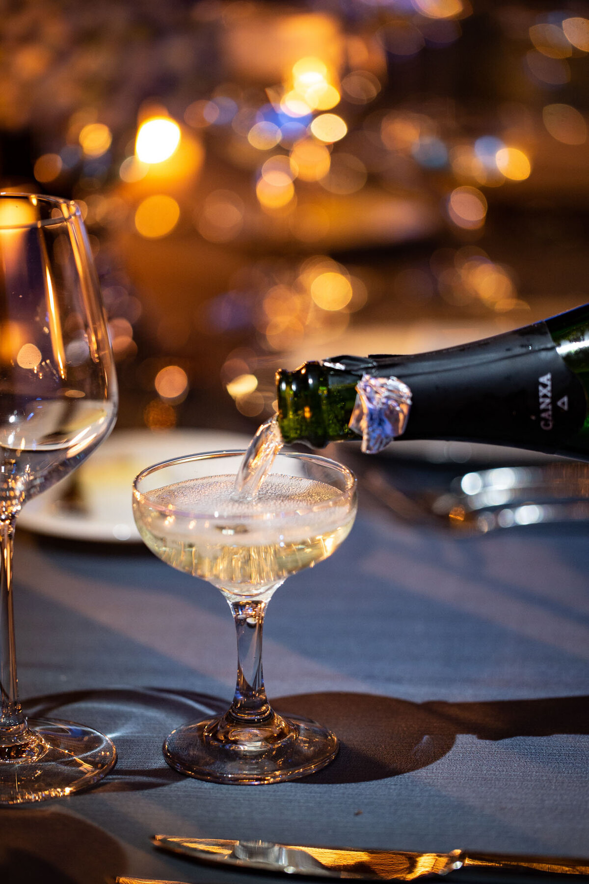 A bottle of canska champagne is being poured into a glass