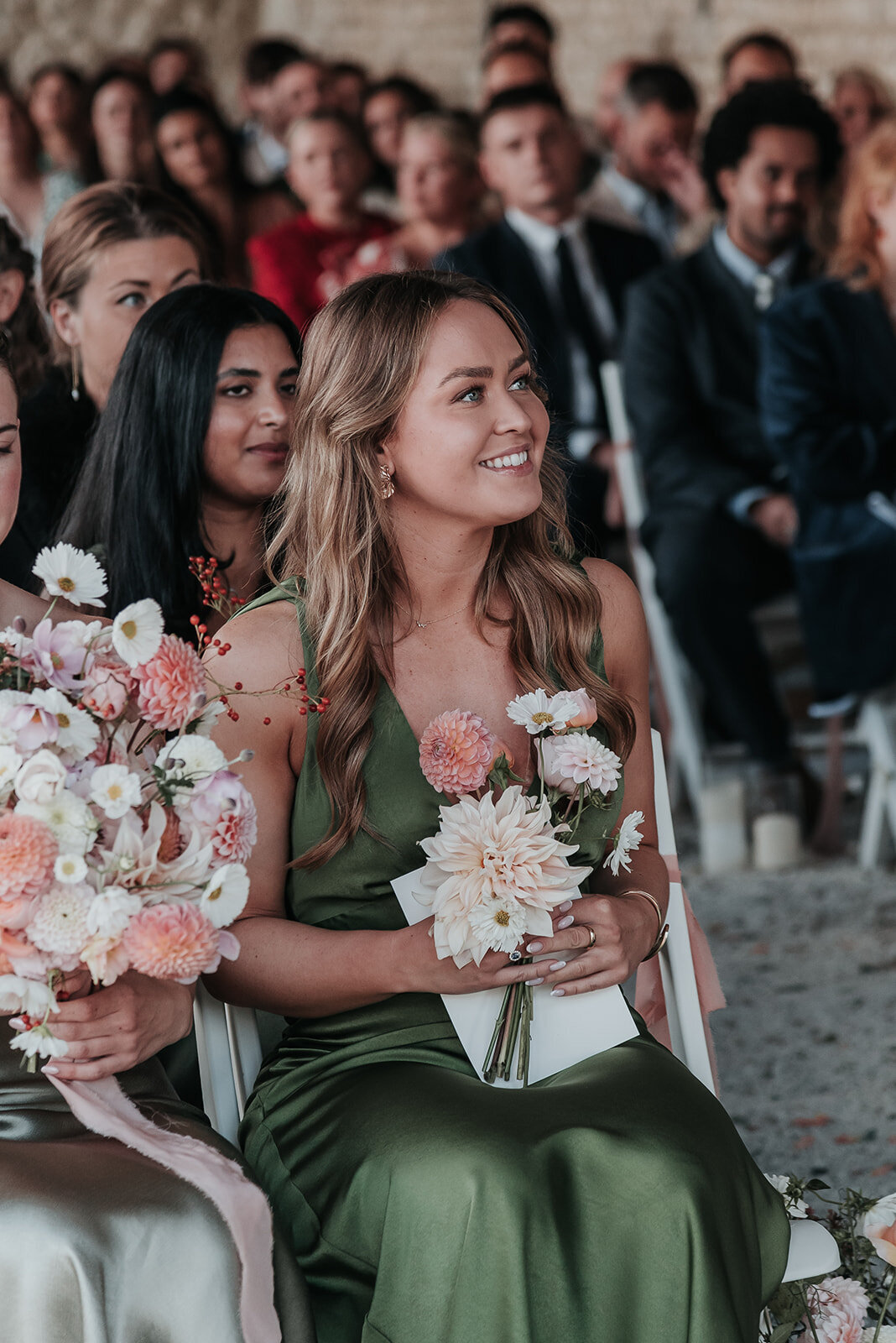 Bridesmaid in sage green dress smiling during wedding ceremony in France