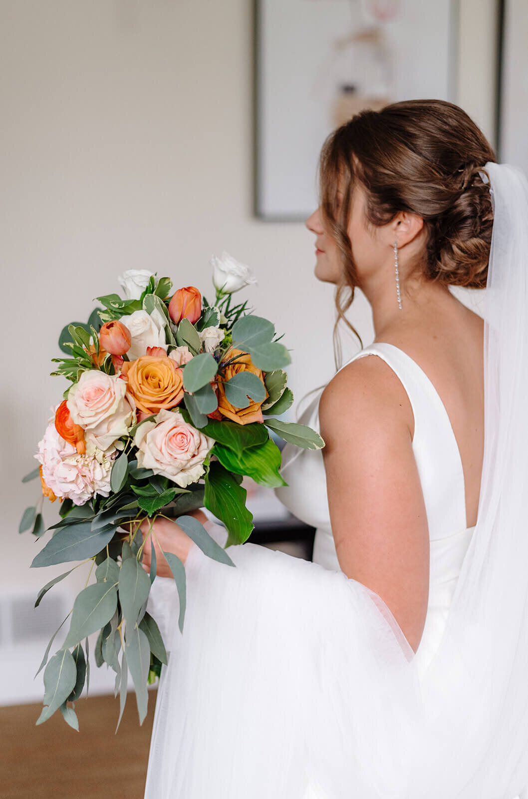 Bride holding bouquet of orange and peach florals
