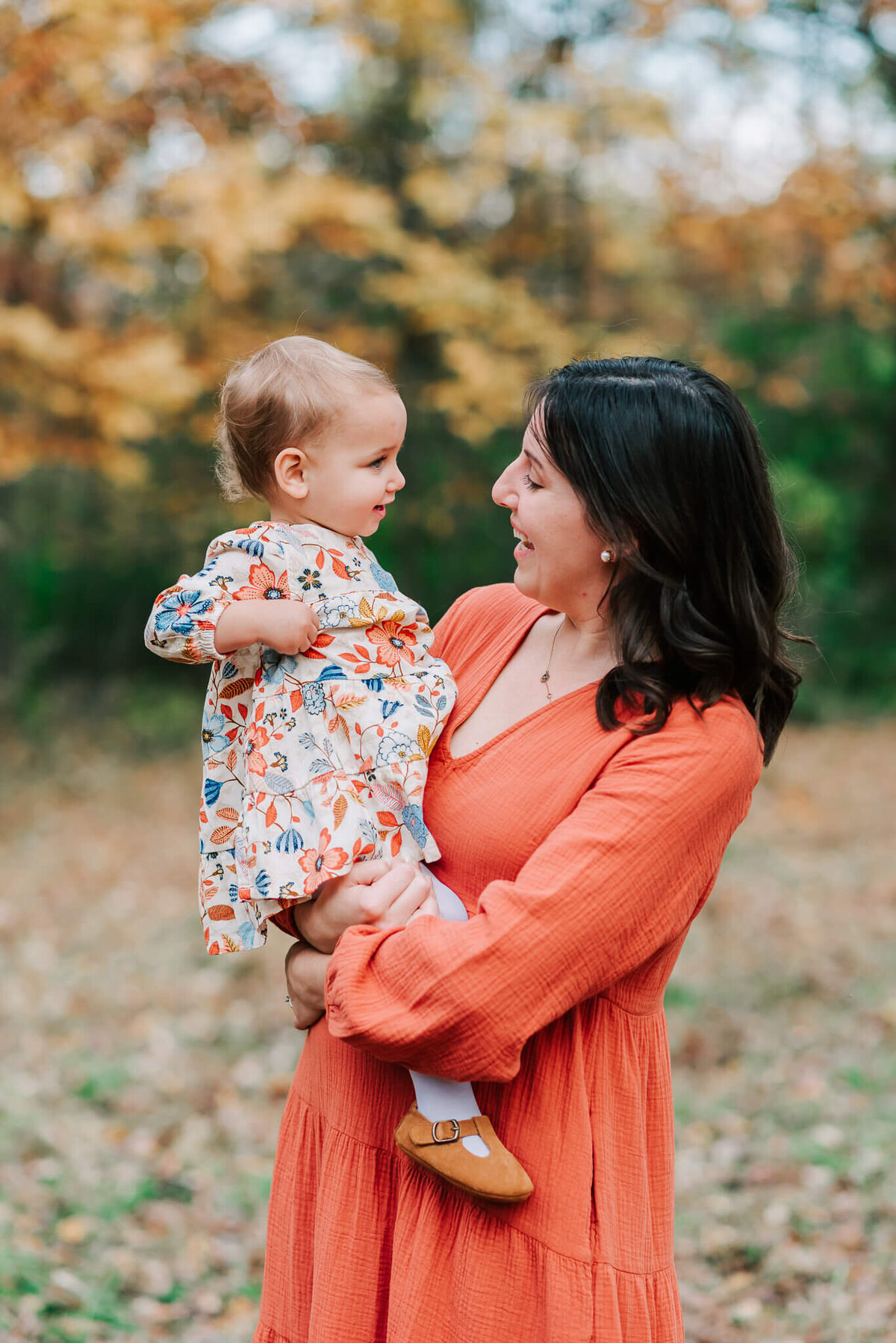 A woman holding her child, smiling at each other