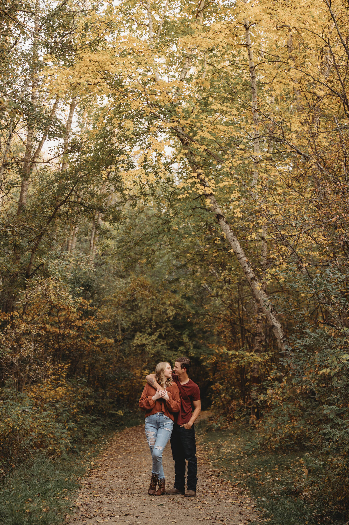 Couple standing amongst the Alberta fall leaves