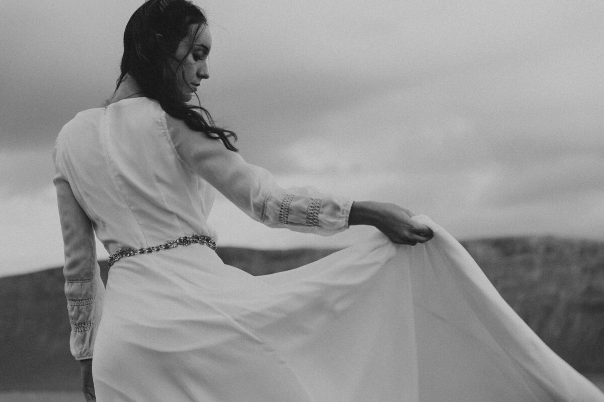 Black and white of bride holding her skirt