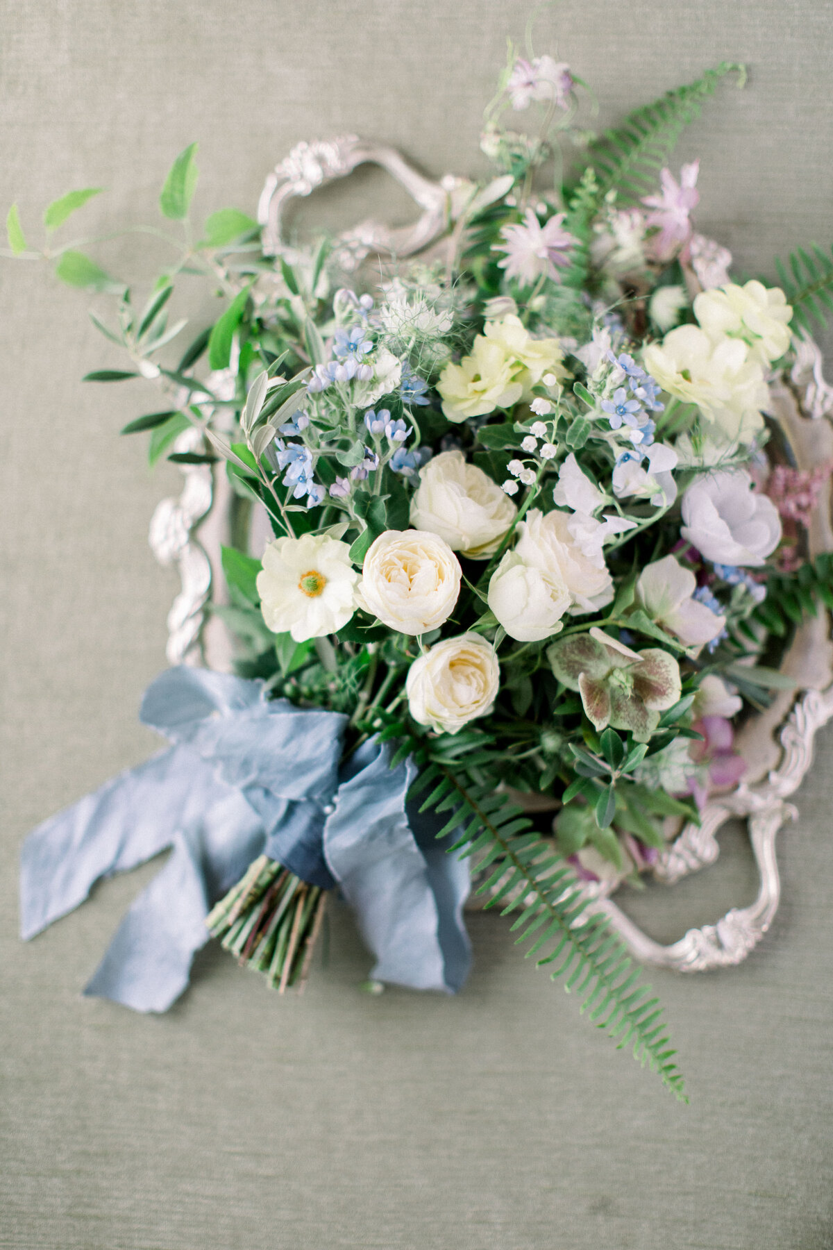 bouquet with ivory, blue and blush florals with greenery and blue satin ribbon by EH Floral