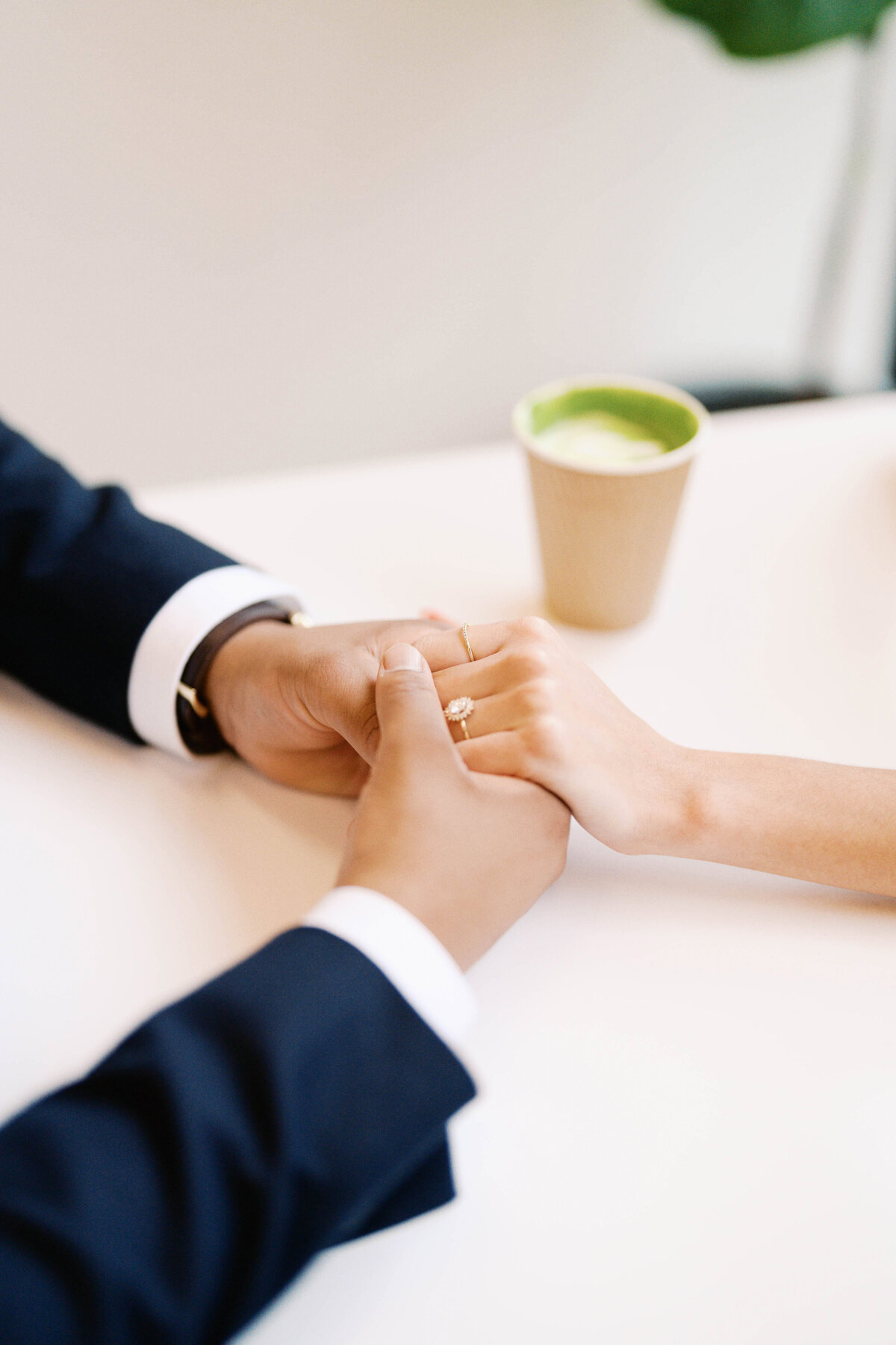 Emily and Sergio hold hands at Heirloom Coffee in downtown Raleigh during their engagement session, a location special to their relationship, captured by North Carolina wedding photographer Jessica Leigh Mason.