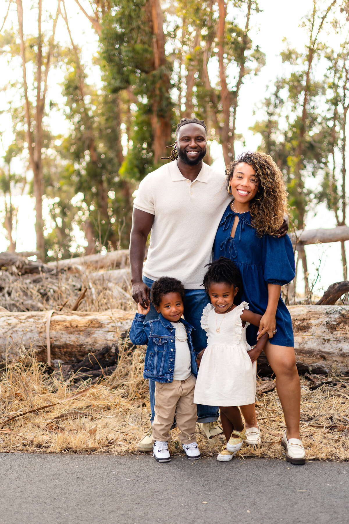 Family of four posing together by logs and trees, Bay Area Family Portfolio – Ellobelle Photography