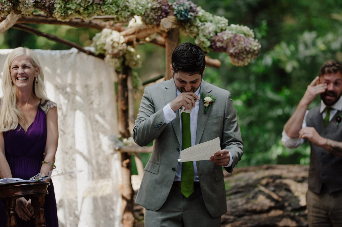 Tearful groom and groomsmen during redwood wedding ceremony