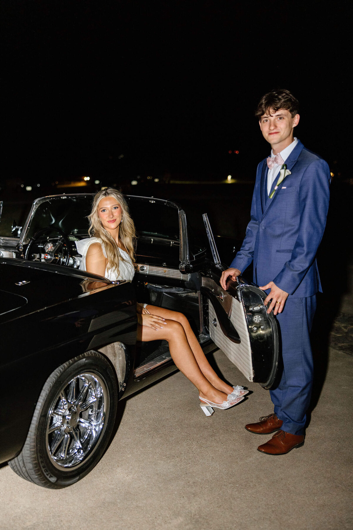 bride and groom getting in vintage car for wedding exit