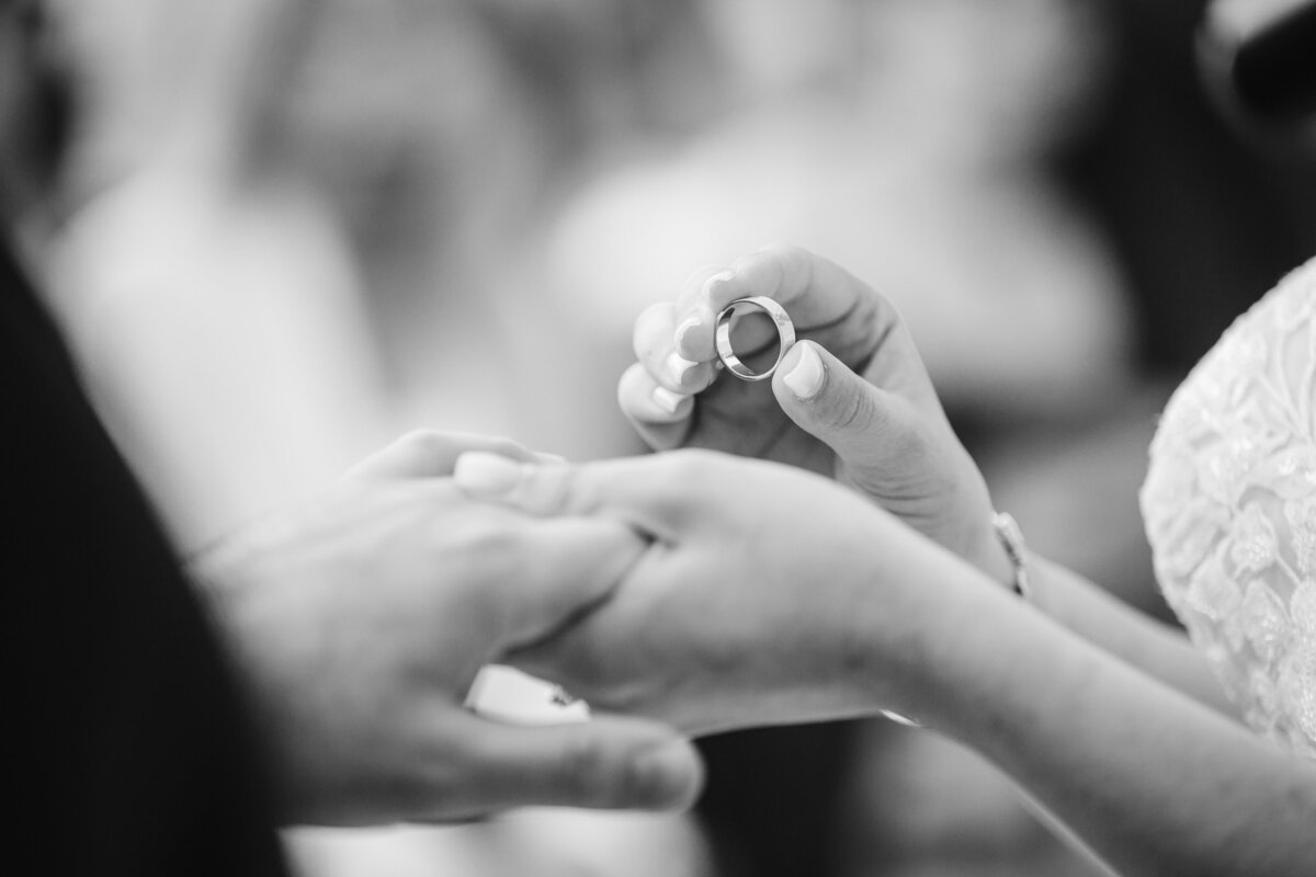 bride putting wedding ring on grooms hand