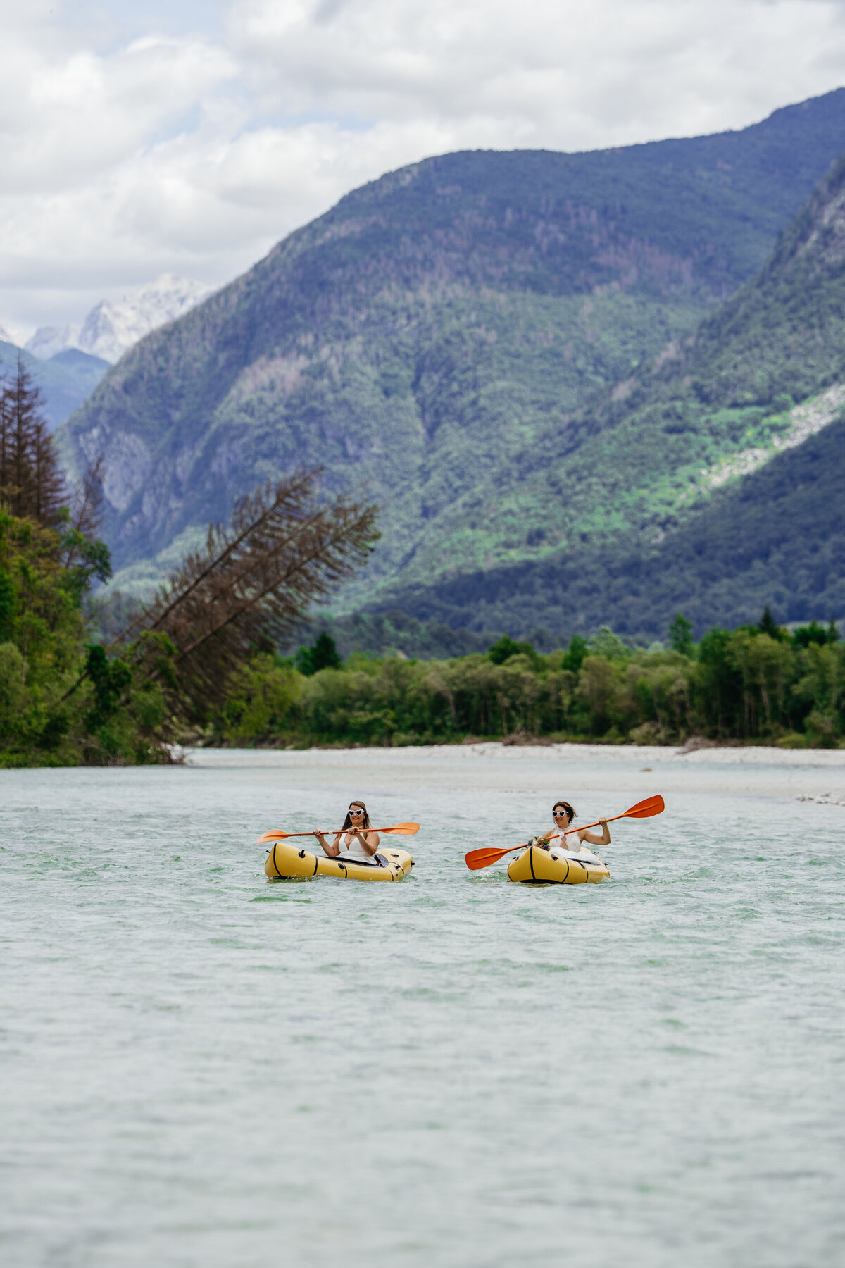 romantic couple in wedding dresses kayaking Soča River