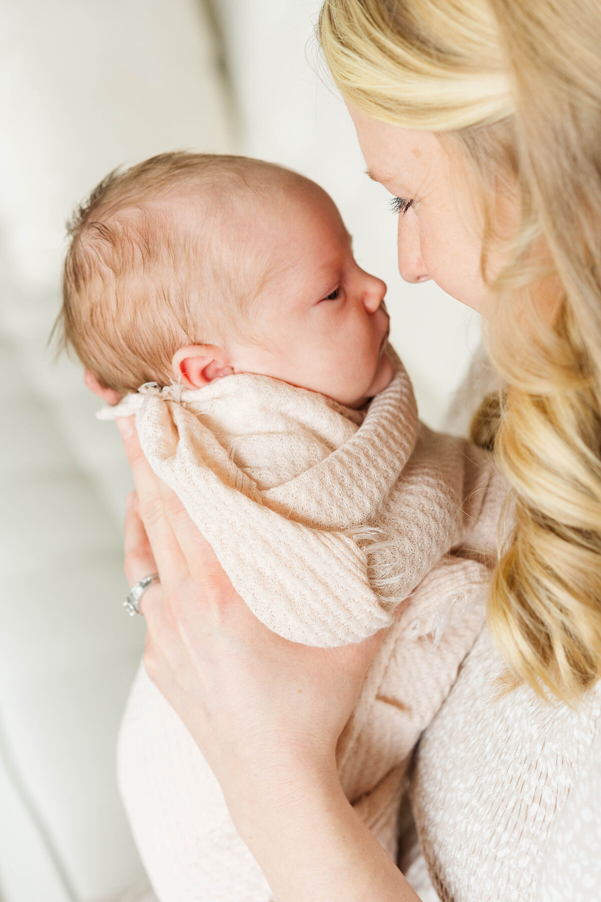 a mother holds her newborn swaddled