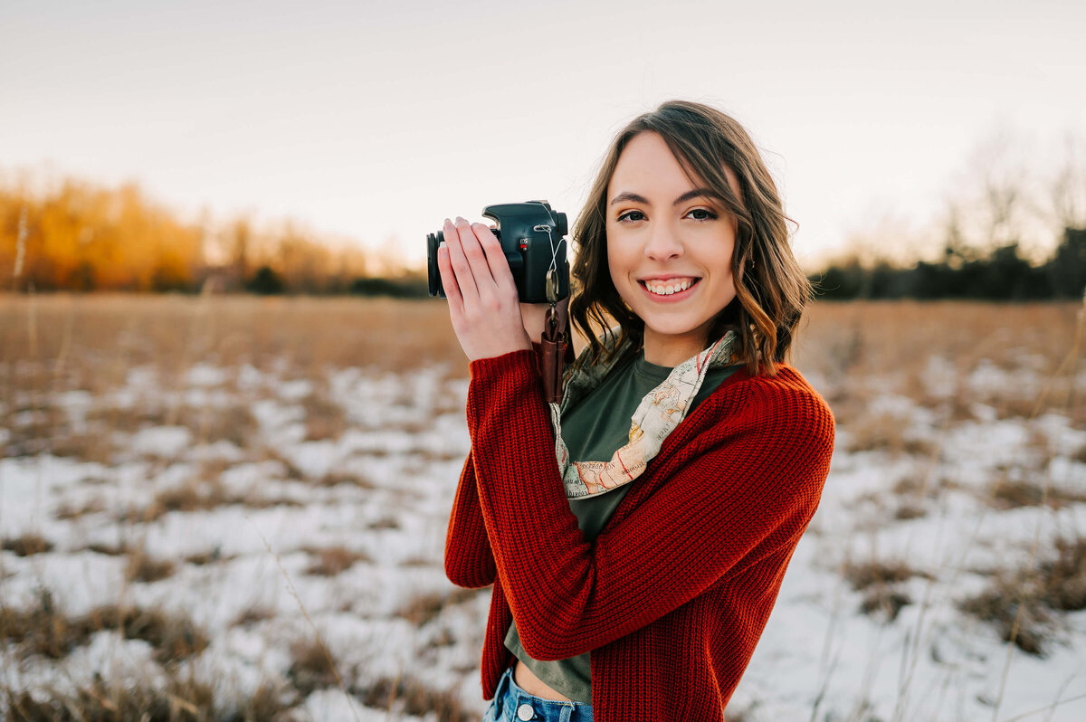Branson Missouri senior photographer captures high school senior smiling holding camera