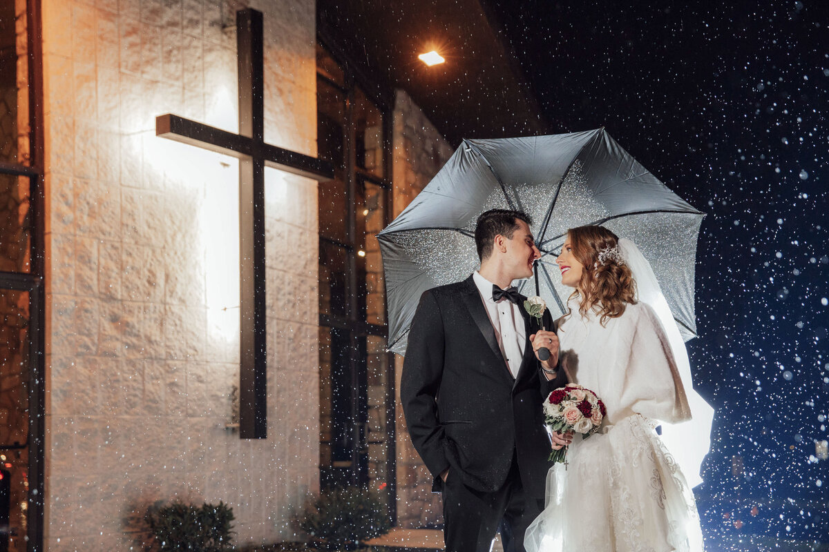St. Frances Cabrini Church | Bride and groom looking at each other under umbrella during winter wedding | Fairless Hills, Pennsylvania