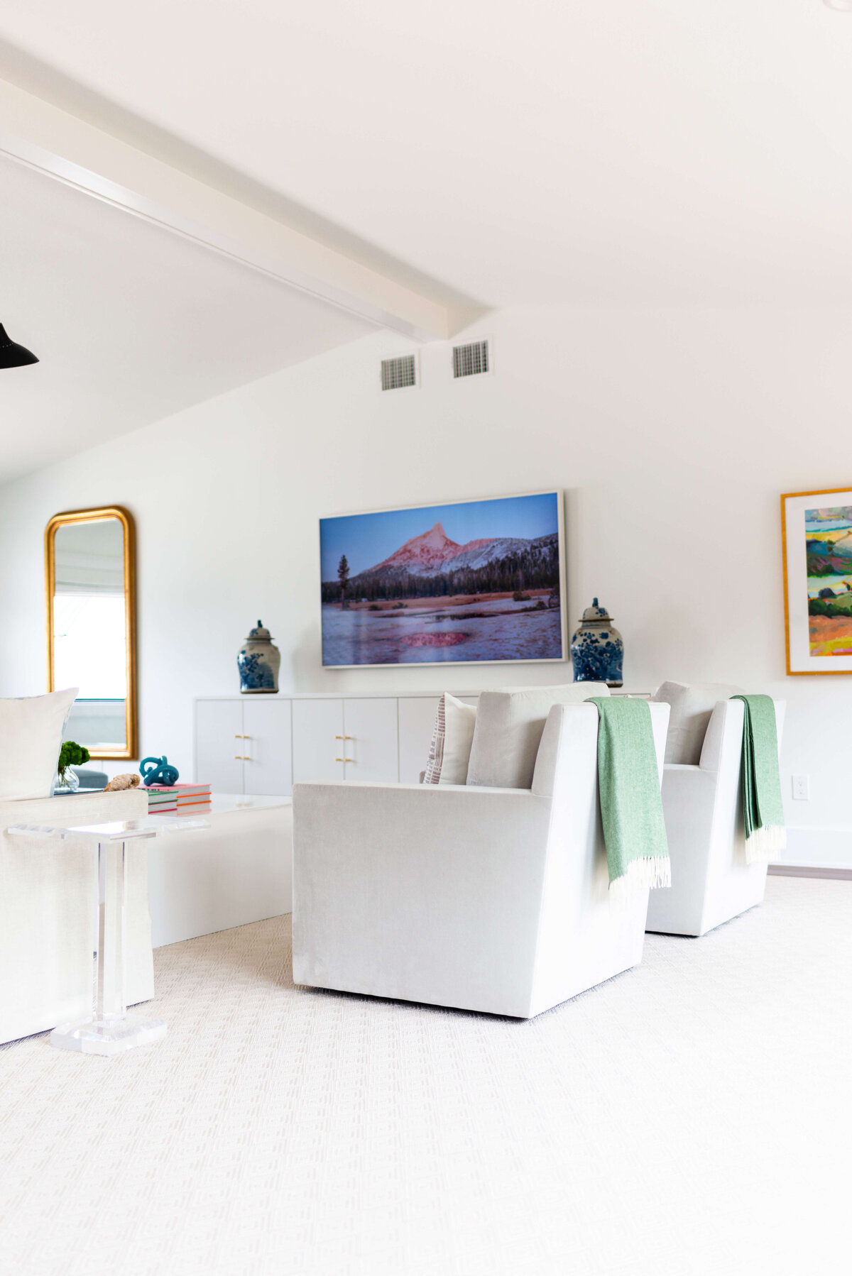 oyster creek studios building belt new build white living room with green pillows and large landscape photography