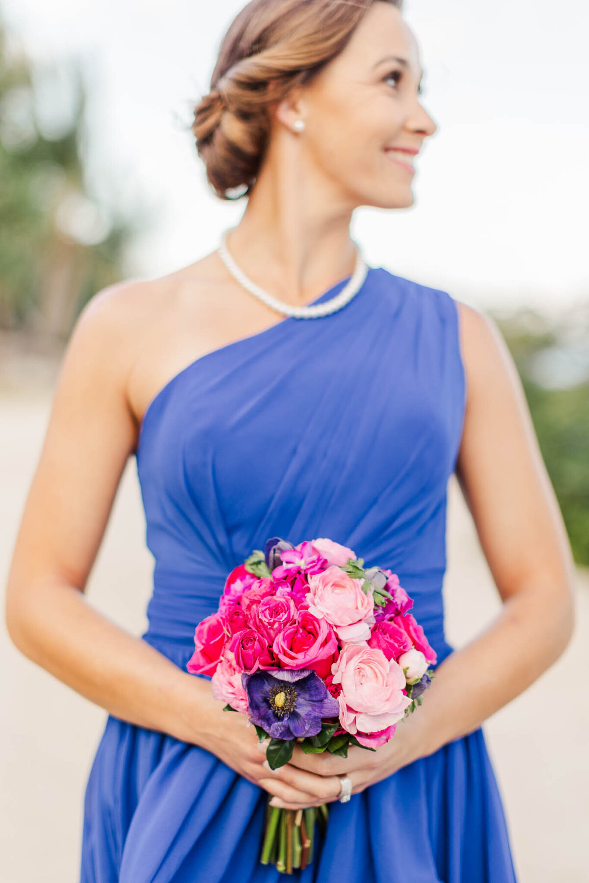 A detailed photo of the bridesmaids bouquets of flowers that are hot pink and purple