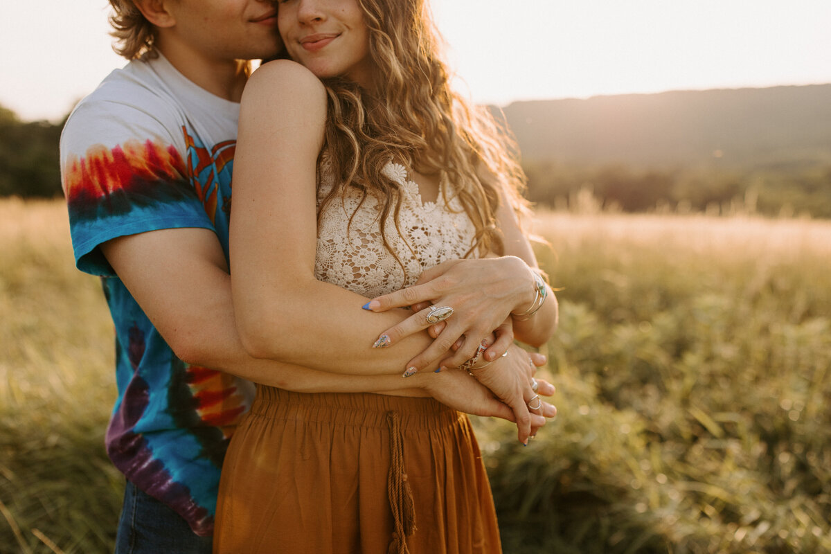 couple standing behind each other with their arms wrapped around each other