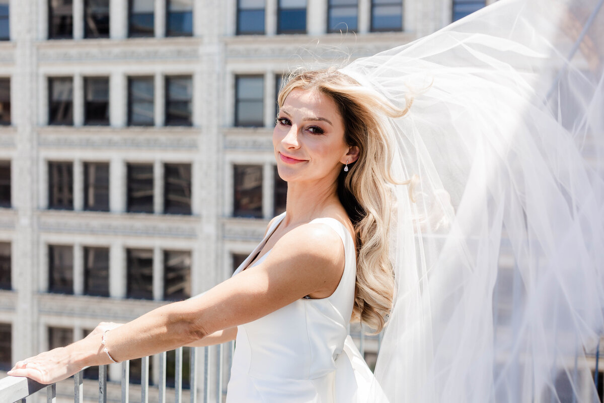 Romantic moment captured by Style & Grace Photography in St. Louis, MO, as the bride’s veil blows in the wind, creating a beautiful, ethereal effect on her wedding day.