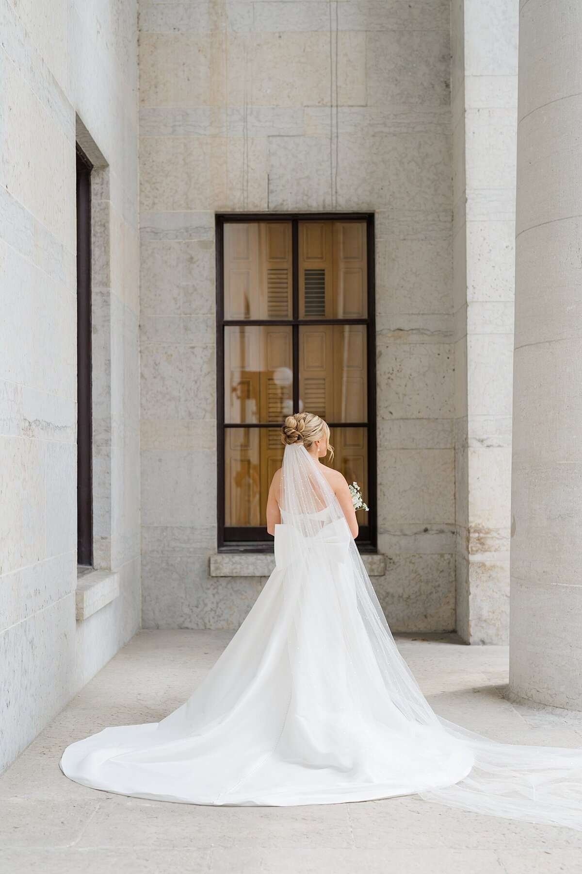 bridal portrait of bride in a ballgown with a long veil posing at the Westin