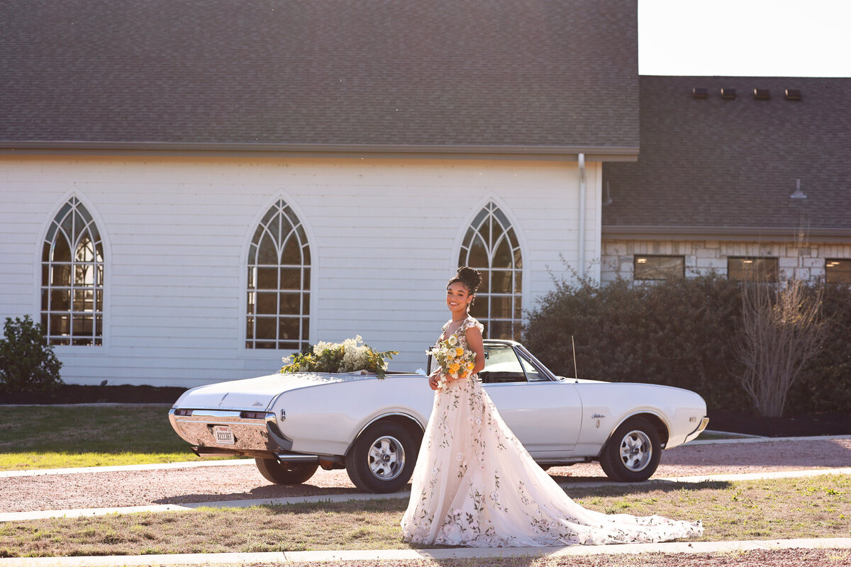 bride walking in front of vintage car at High Pointe Estate in Austin Texas by Austin Texas Wedding Photographer Amanda Richardson Photography