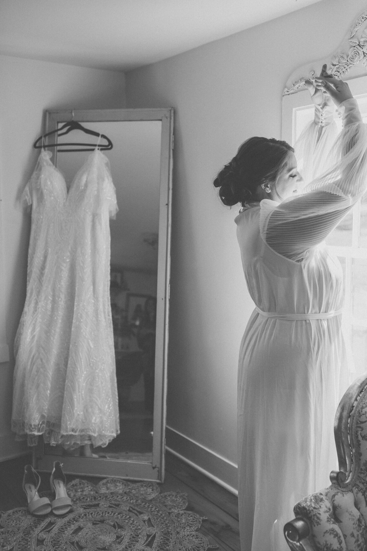 Bride holding the skirt of her gown during black and white portraits at Beaufort Hotel Wedding