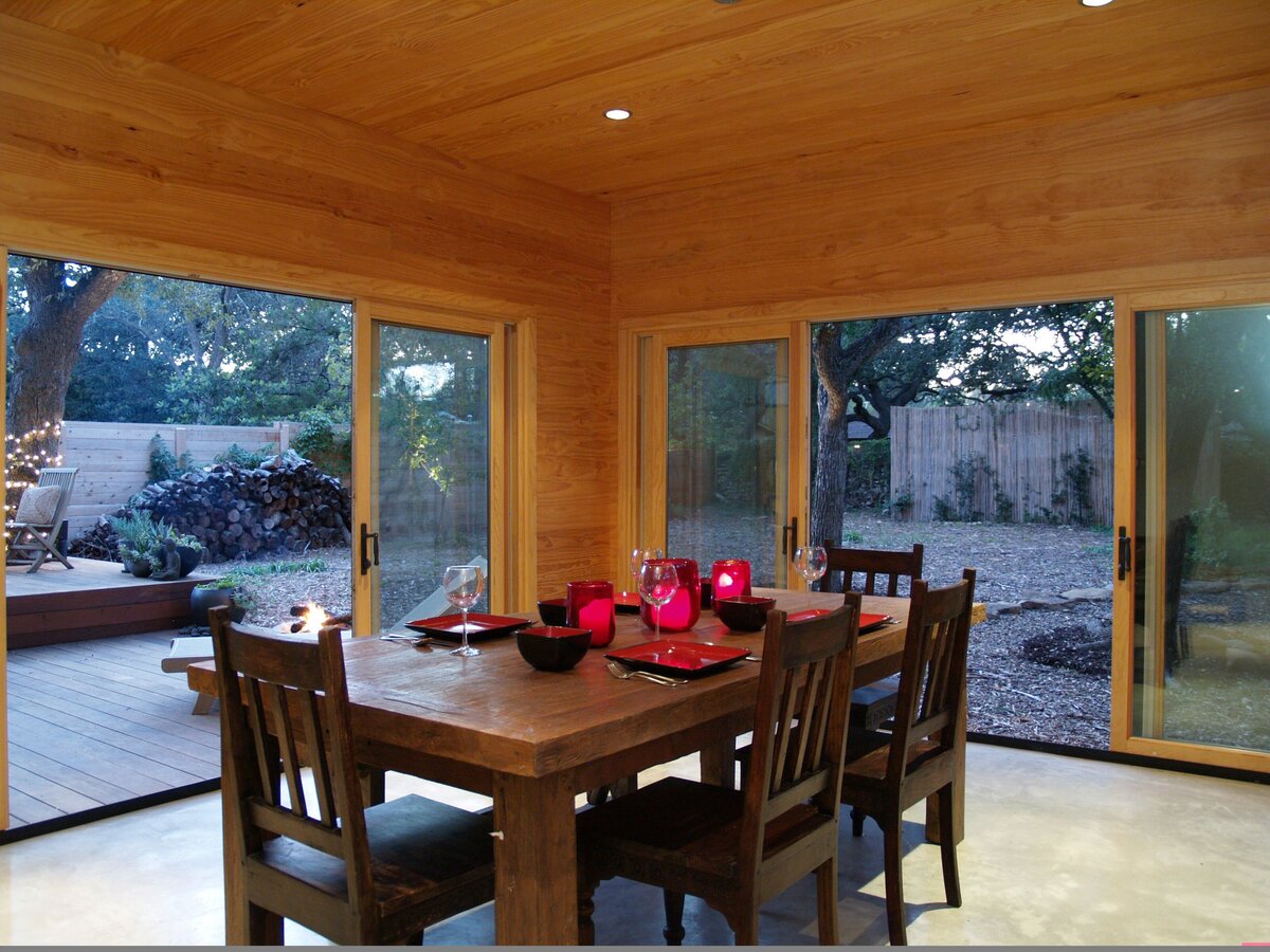 spacious modern dining room with walk-out glass doors and solid oak dinner table.