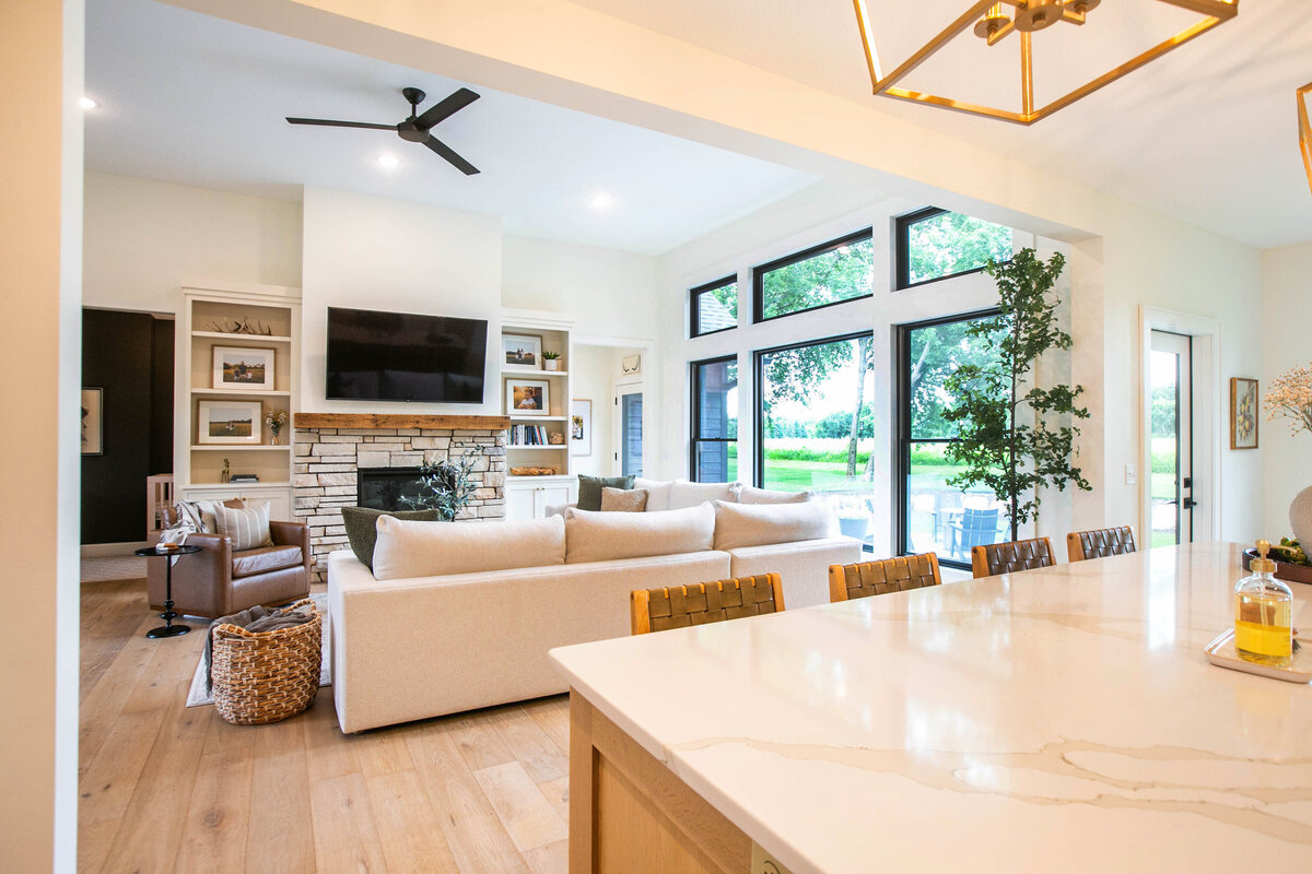 Open kitchen with white cabinets, large island, and quartz countertops in an Otsego custom home