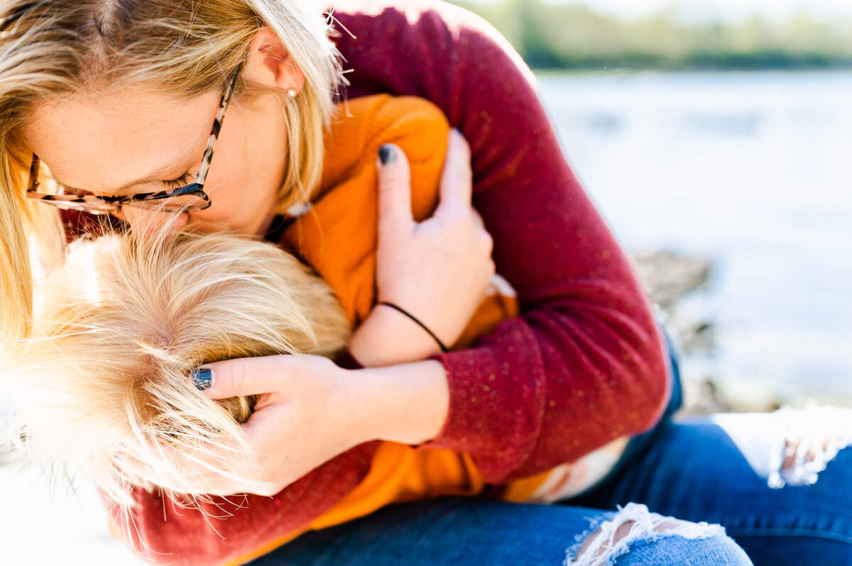 Mother comforting son along the Fox River in Geneva, IL.