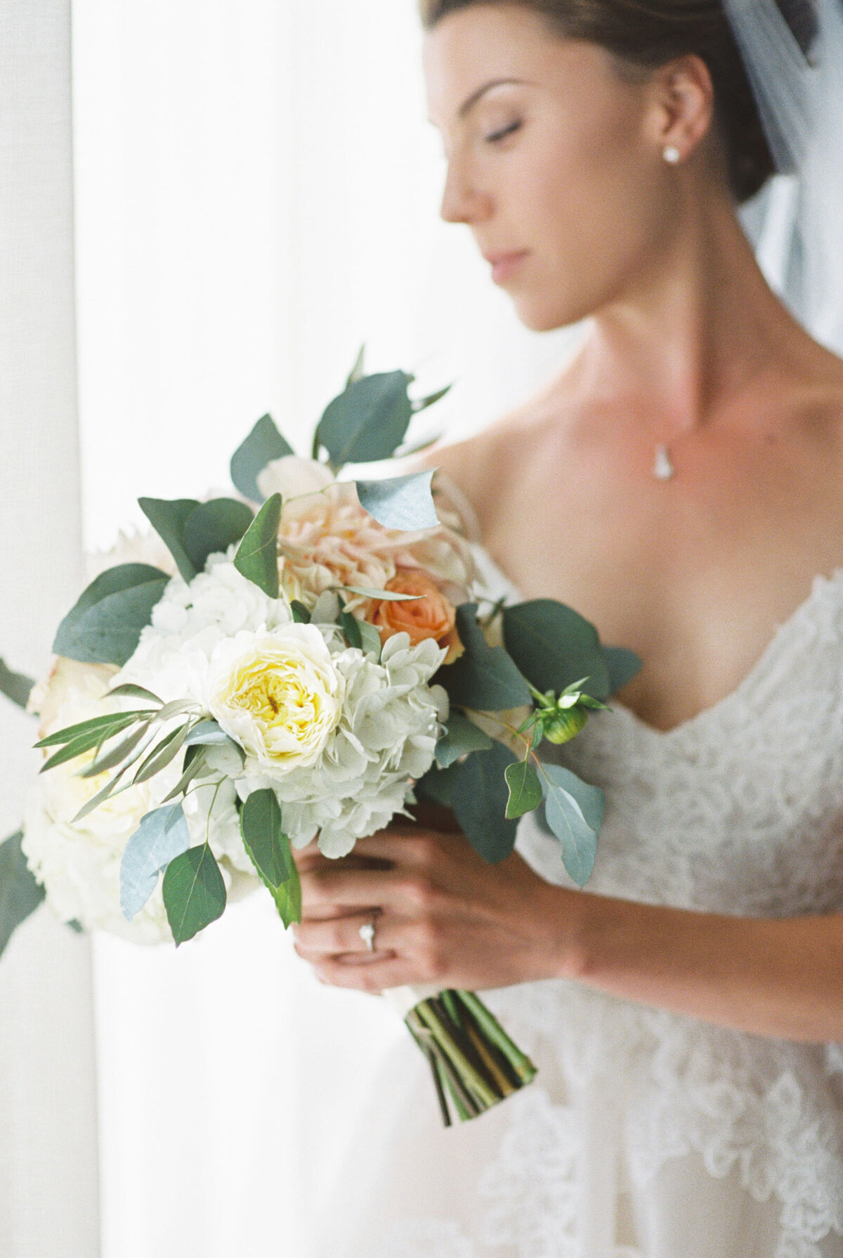 bride holding peach and white blum floral bridal bouquet