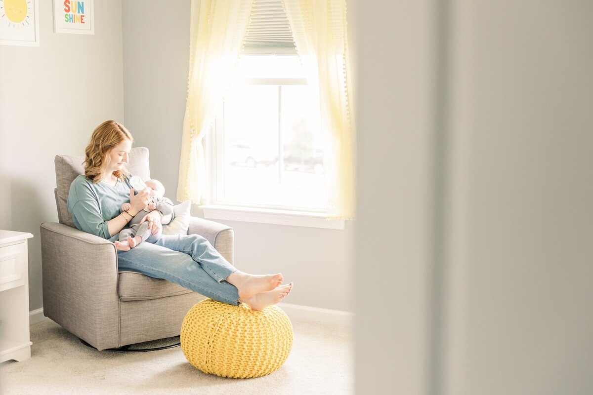 Mom sitting in a rocking chair feeding her baby in an Ohio lifestyle newborn session