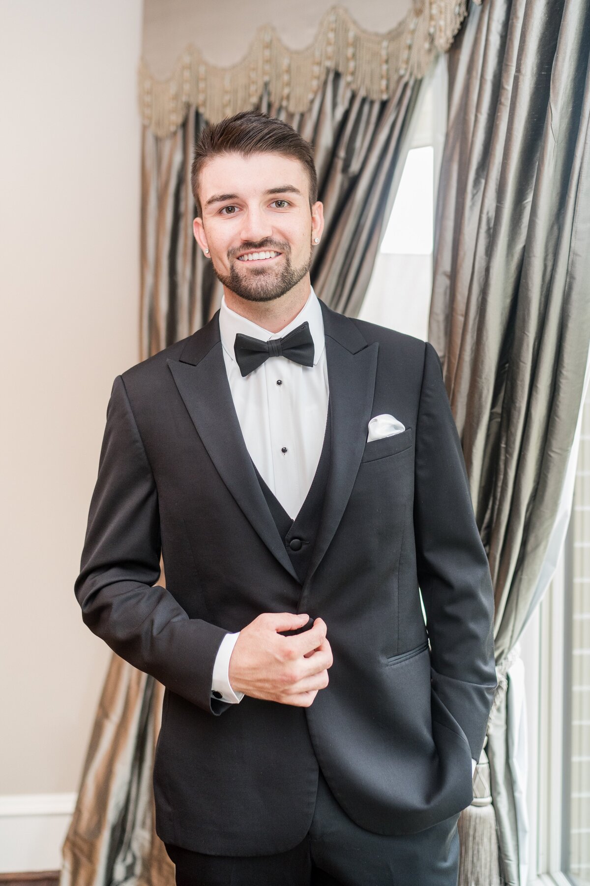 groom posing in tuxedo