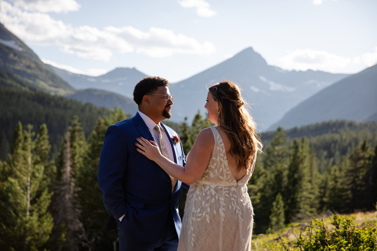 A bride stands with her hand on her groom's chest on their wedding day.