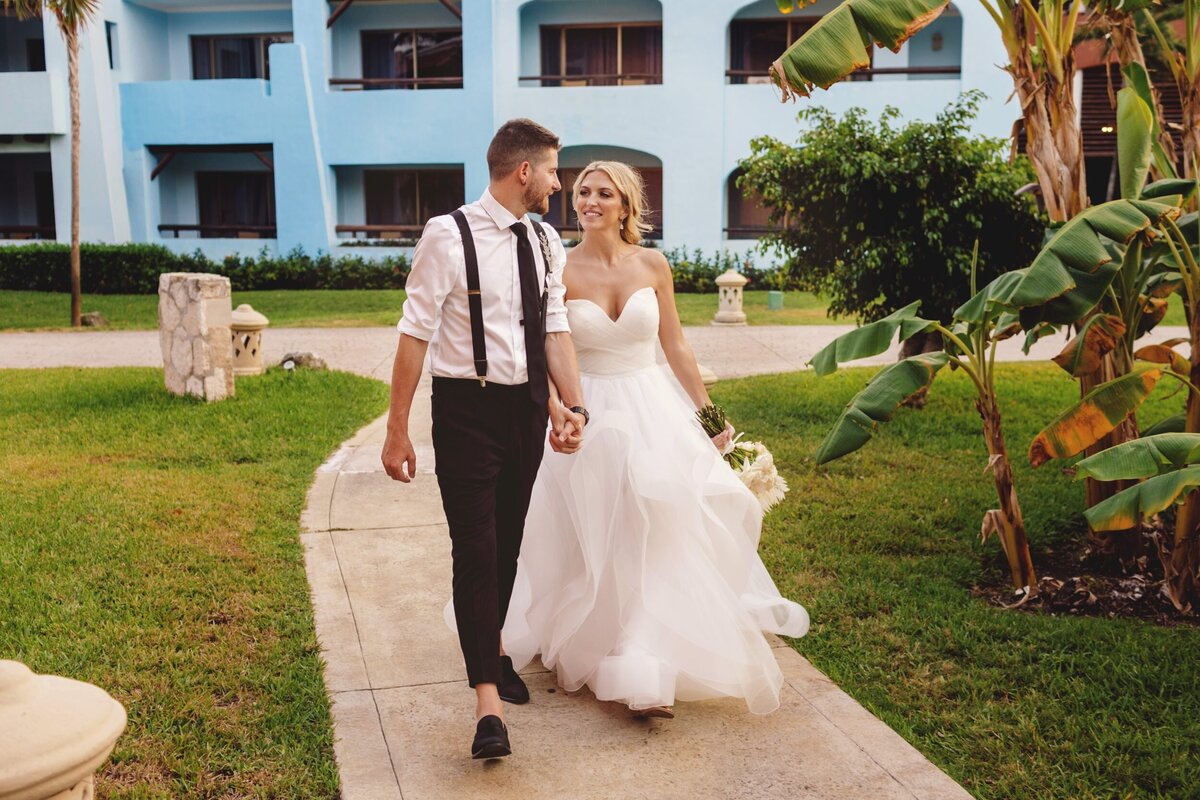 Bride and groom walking through gardens at  Iberostar Paraiso Riviera Maya Wedding