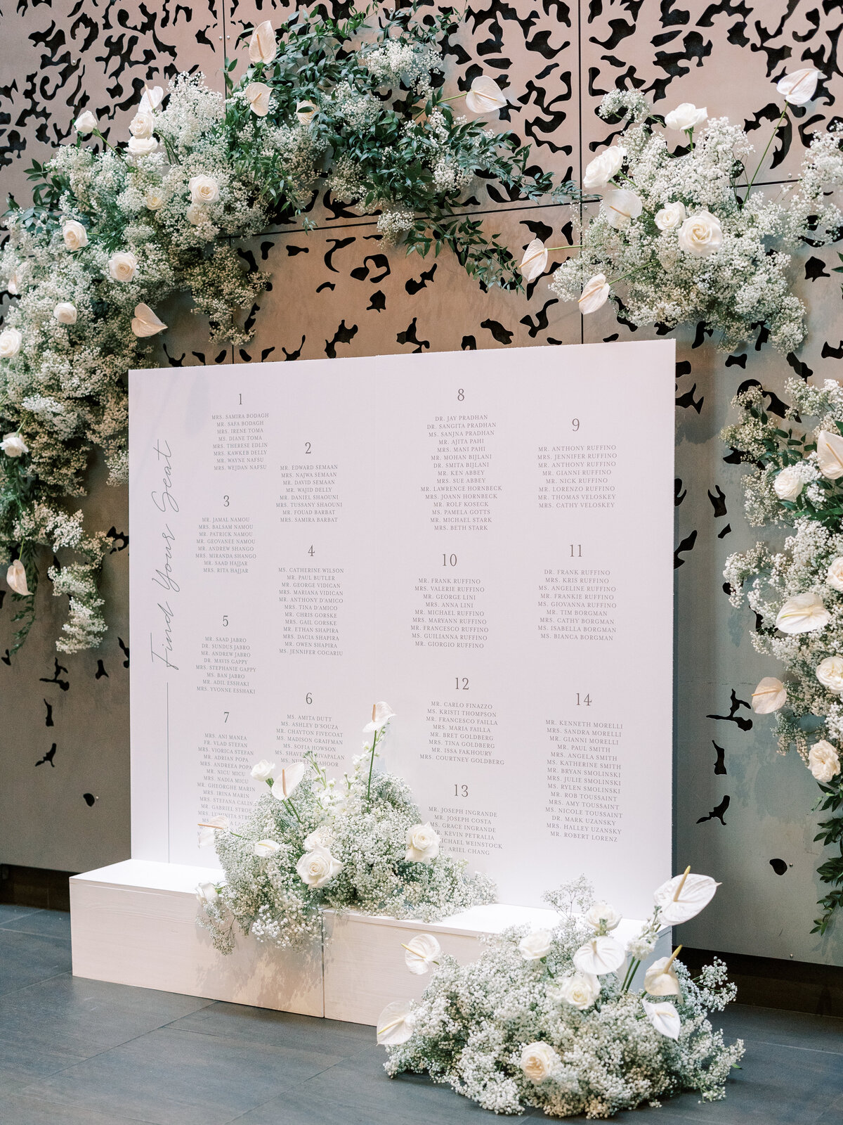 a custom wedding signage design  seating chart with white flowers and babys breath at a luxury alyssa amez design wedding