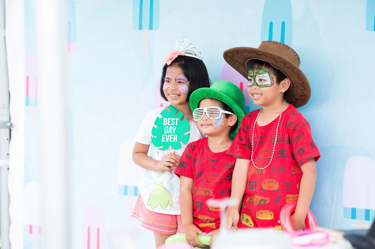 children dressed in red t-shirts enjoying the photobooth at a corporate children's event.  Captured by Ottawa Event Photographer JEMMAN Photography COMMERCIAL