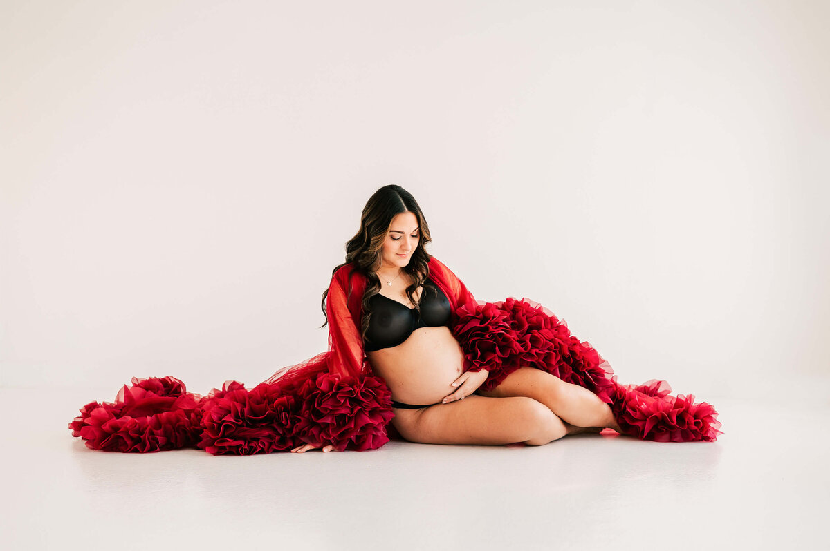 Springfield MO maternity picture of pregnant mom sitting in red robe in studio