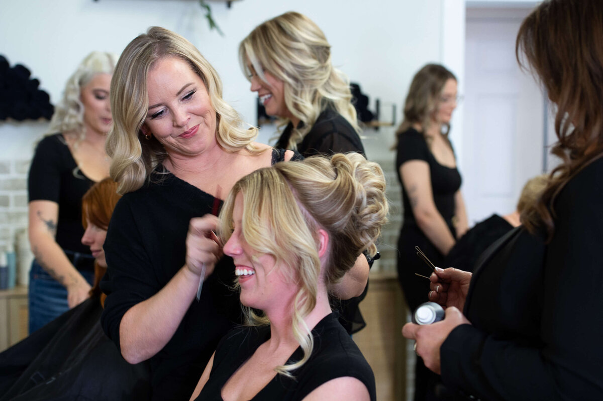 Ottawa brand photography showing of a hair stylist pinning a bridal updo.  Captured on-site at Richardson Hair Design by JEMMAN Photography