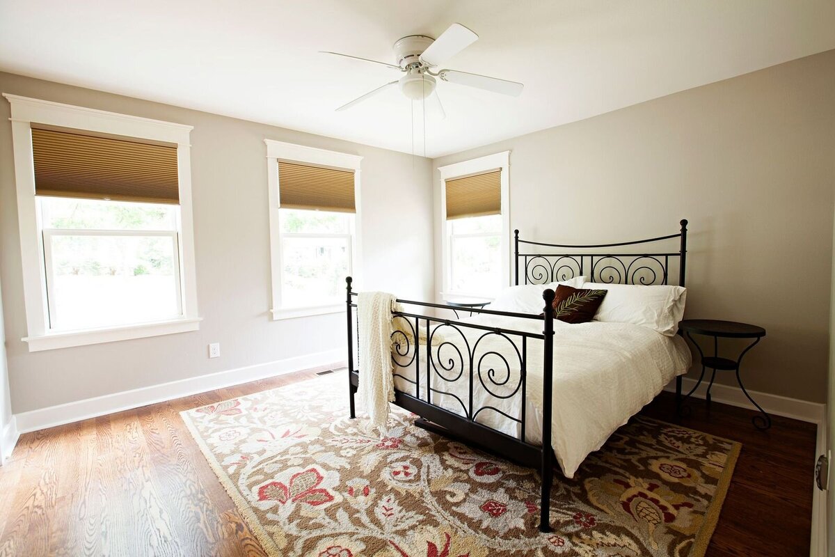 guest bedroom with iron bed frame and beautiful bedroom accent rug