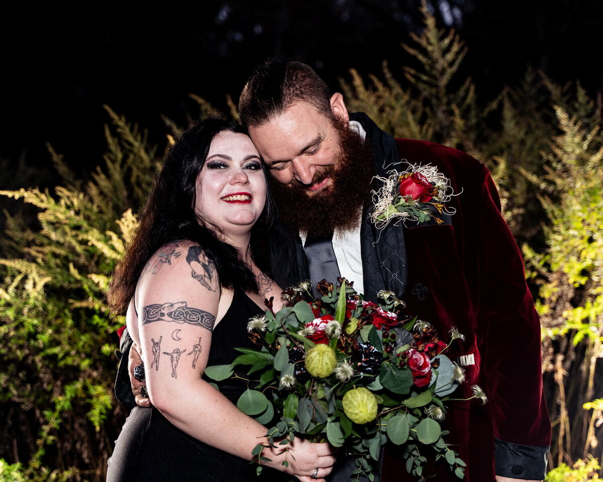 posed image of straight White couple posing during an alternative Halloween wedding at night