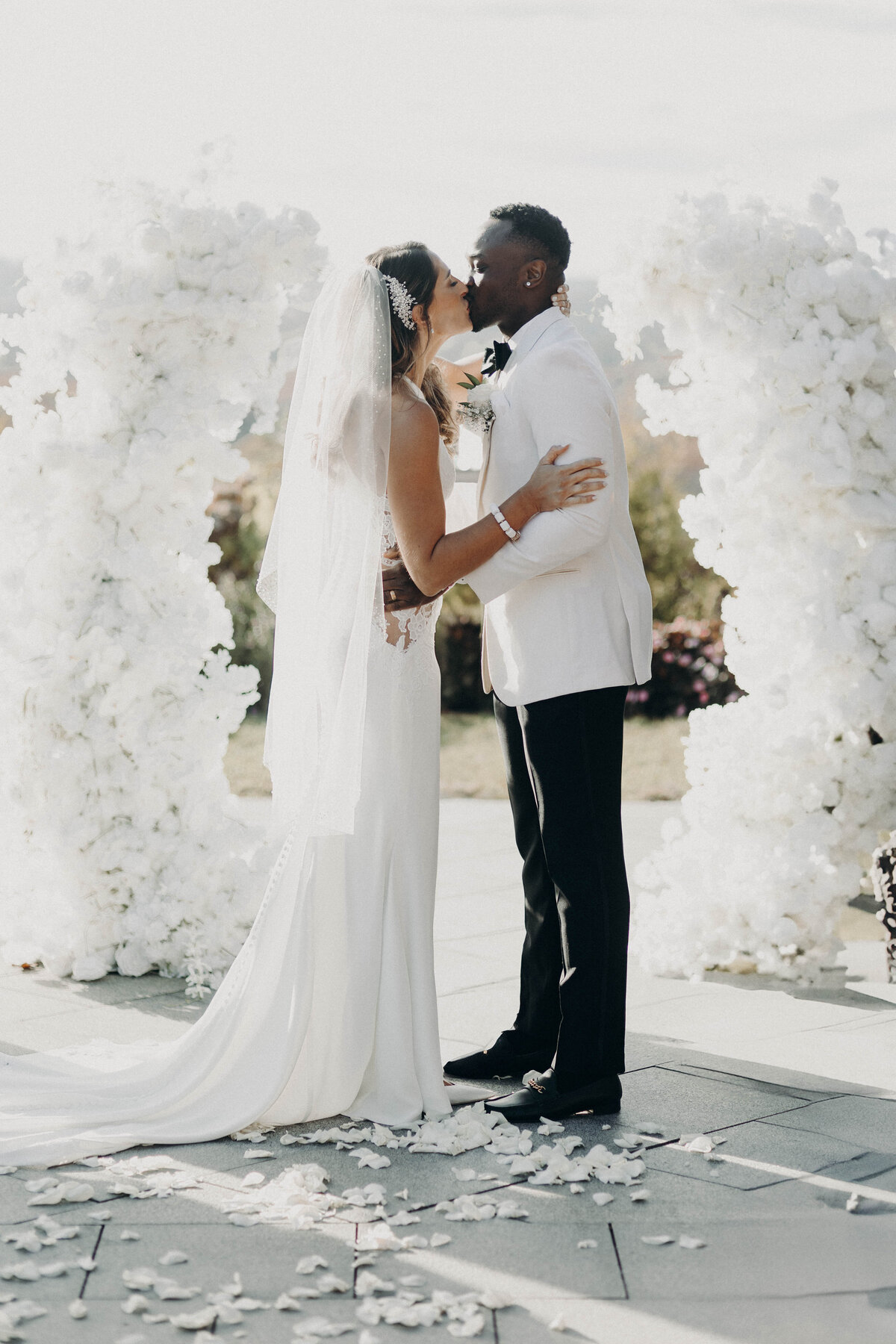 first kiss wedding photography interracial couple floral arch ceremony decor