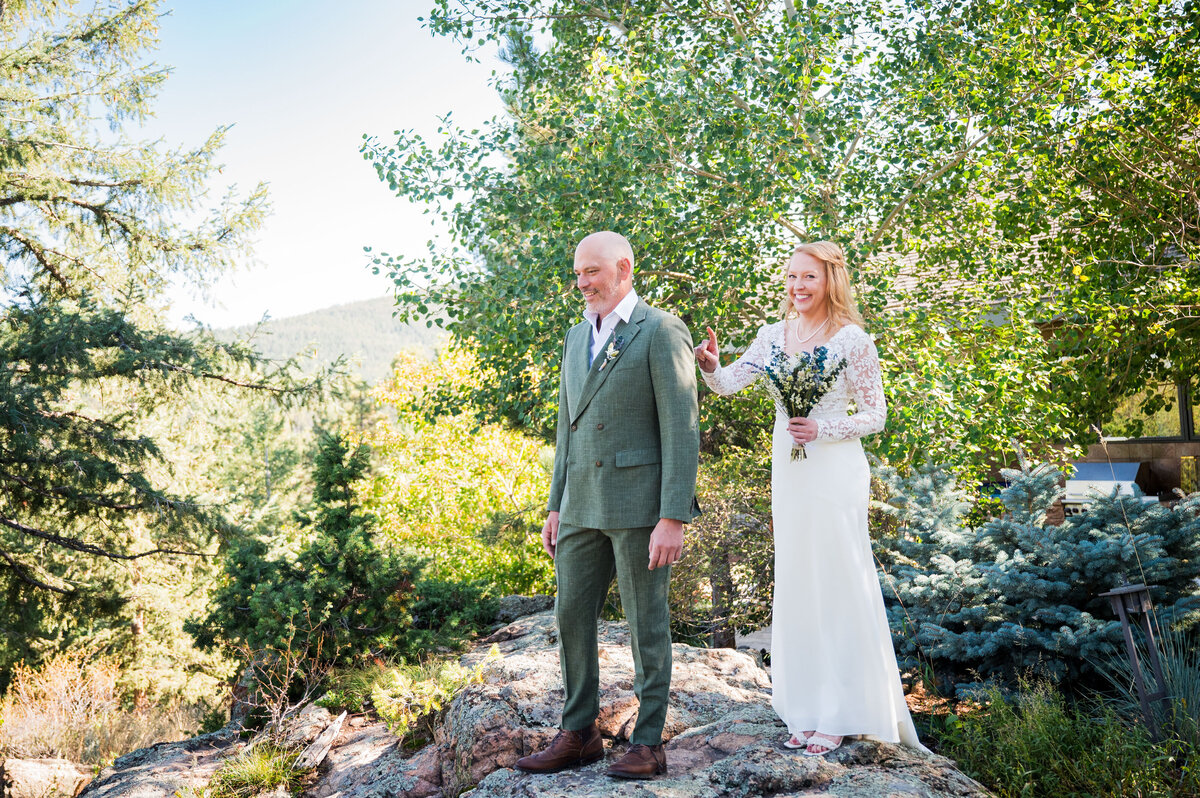 A bride taps her groom on the shoulder as they get ready to share their first look, captured by Colorado wedding photographer, Casey Van Horn.
