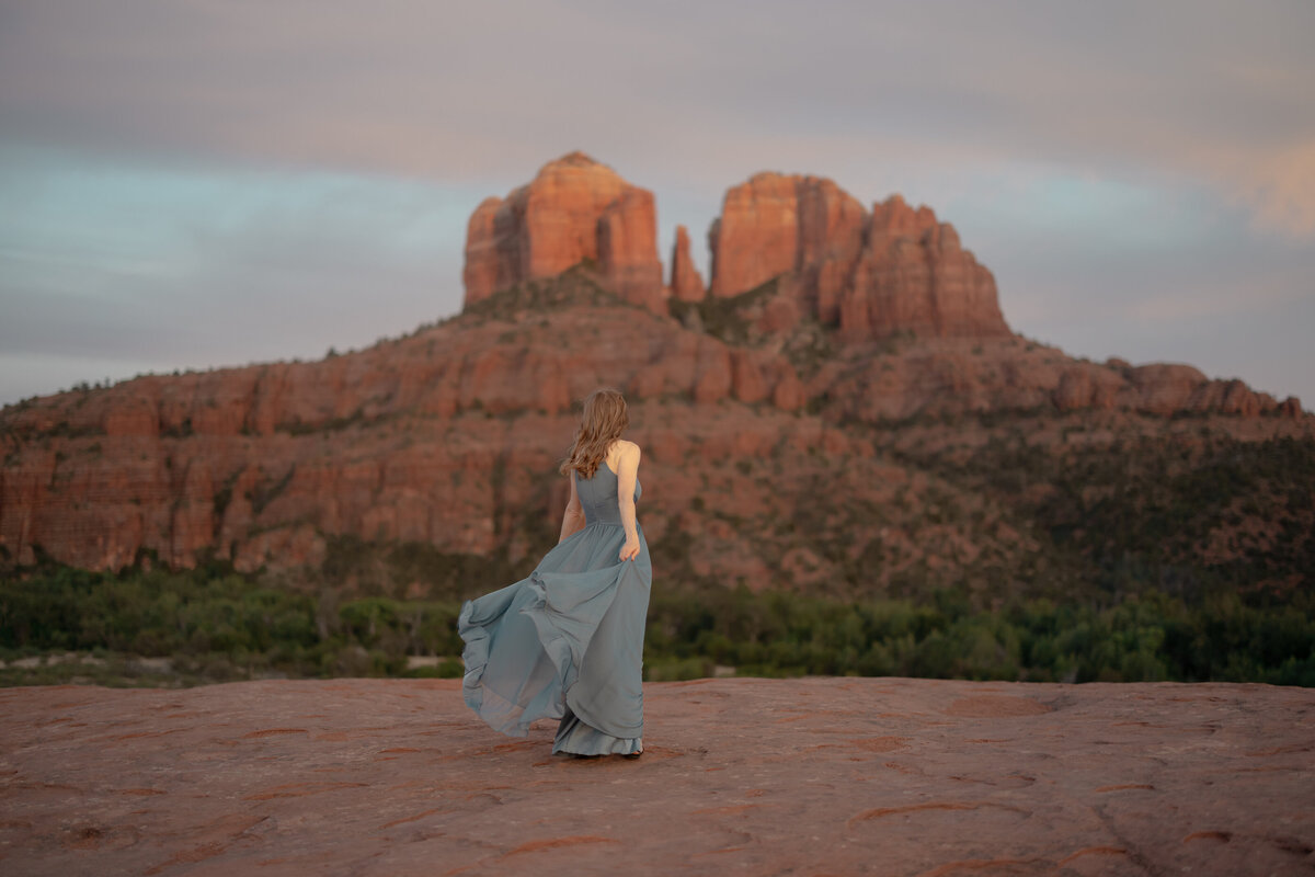 Couple standing against red rock backdrop during Sedona engagement session