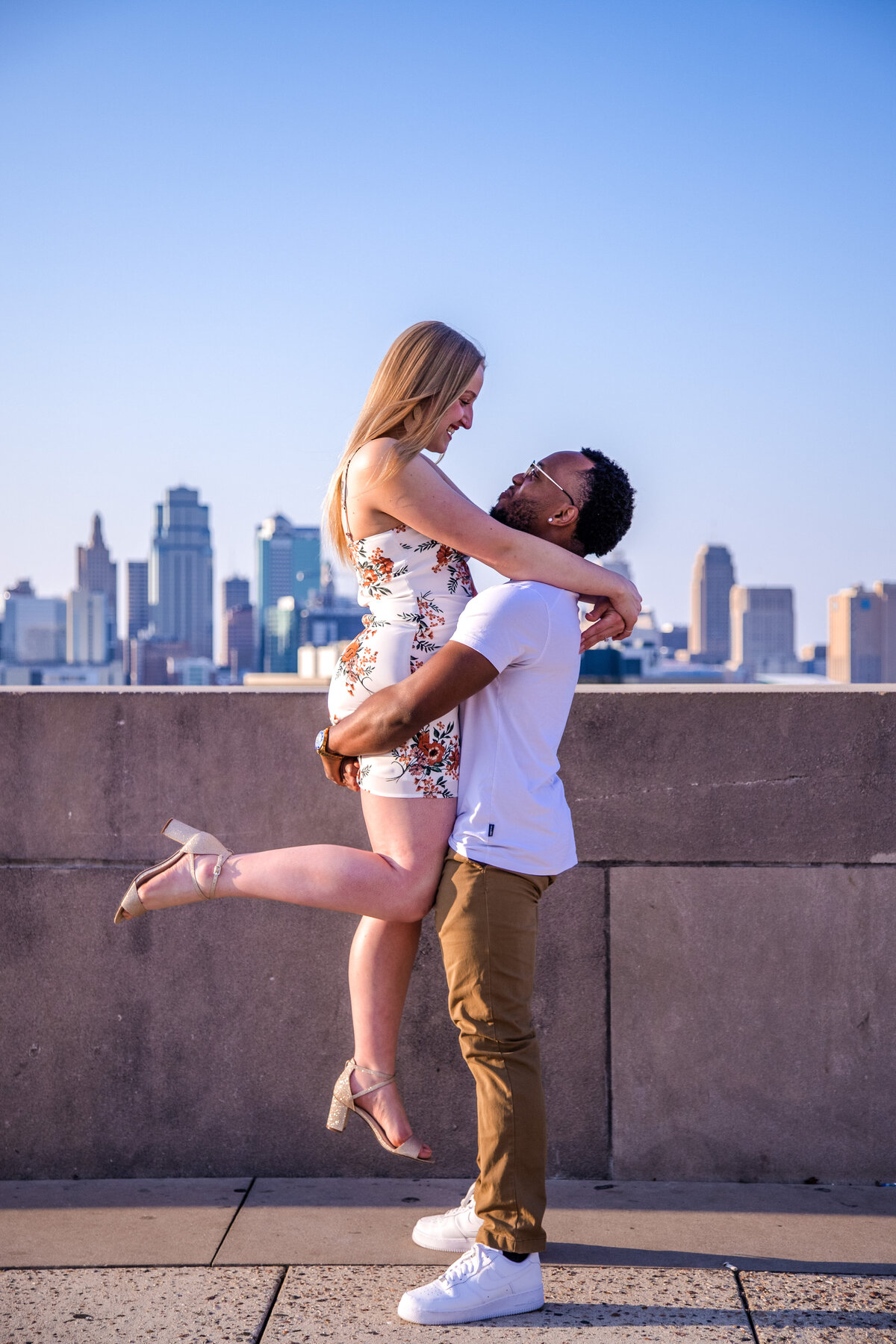 engaged couple embrace on phoenix rooftop