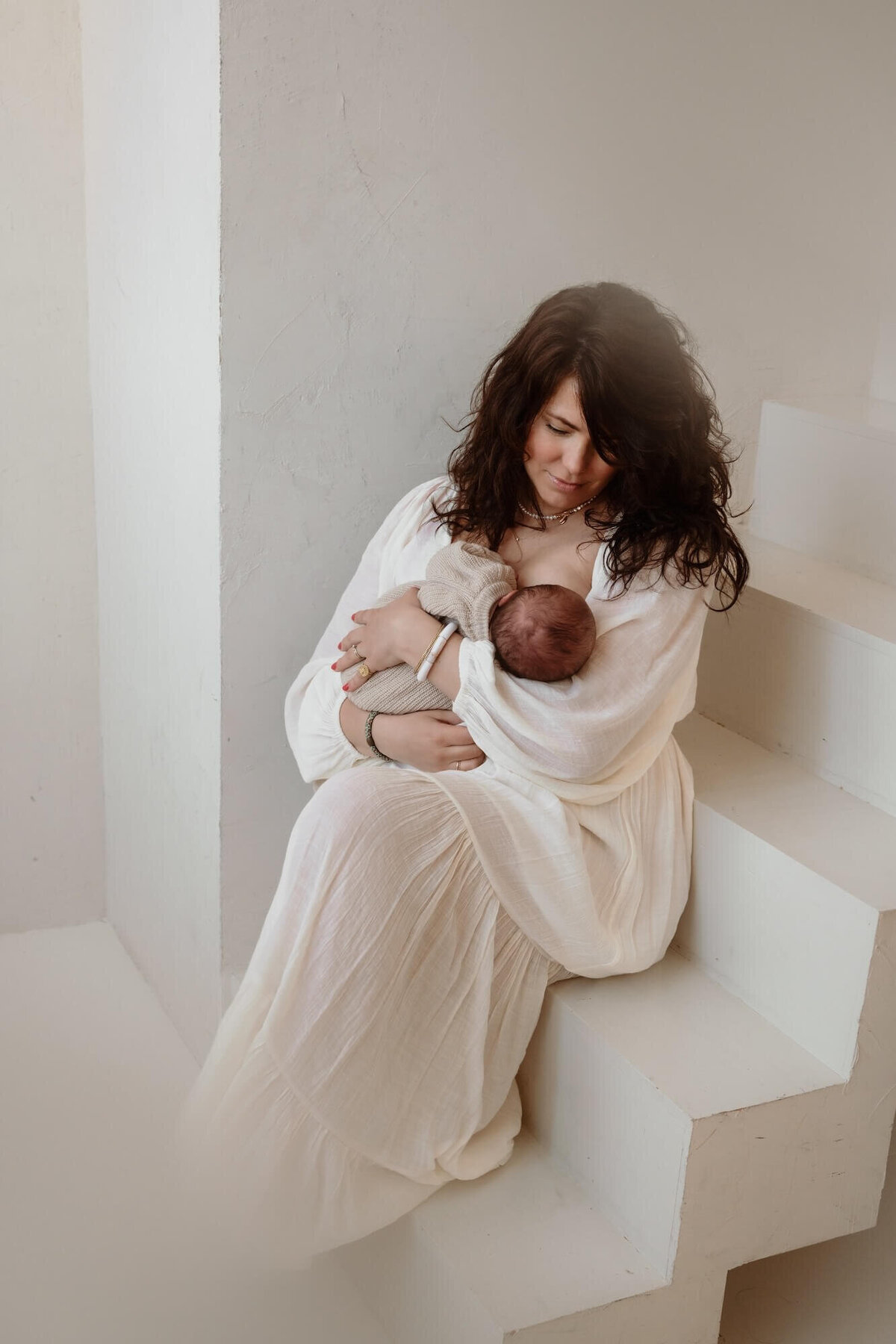 Borstvoeding sessie tijdens newbornshoot in daglicht studio