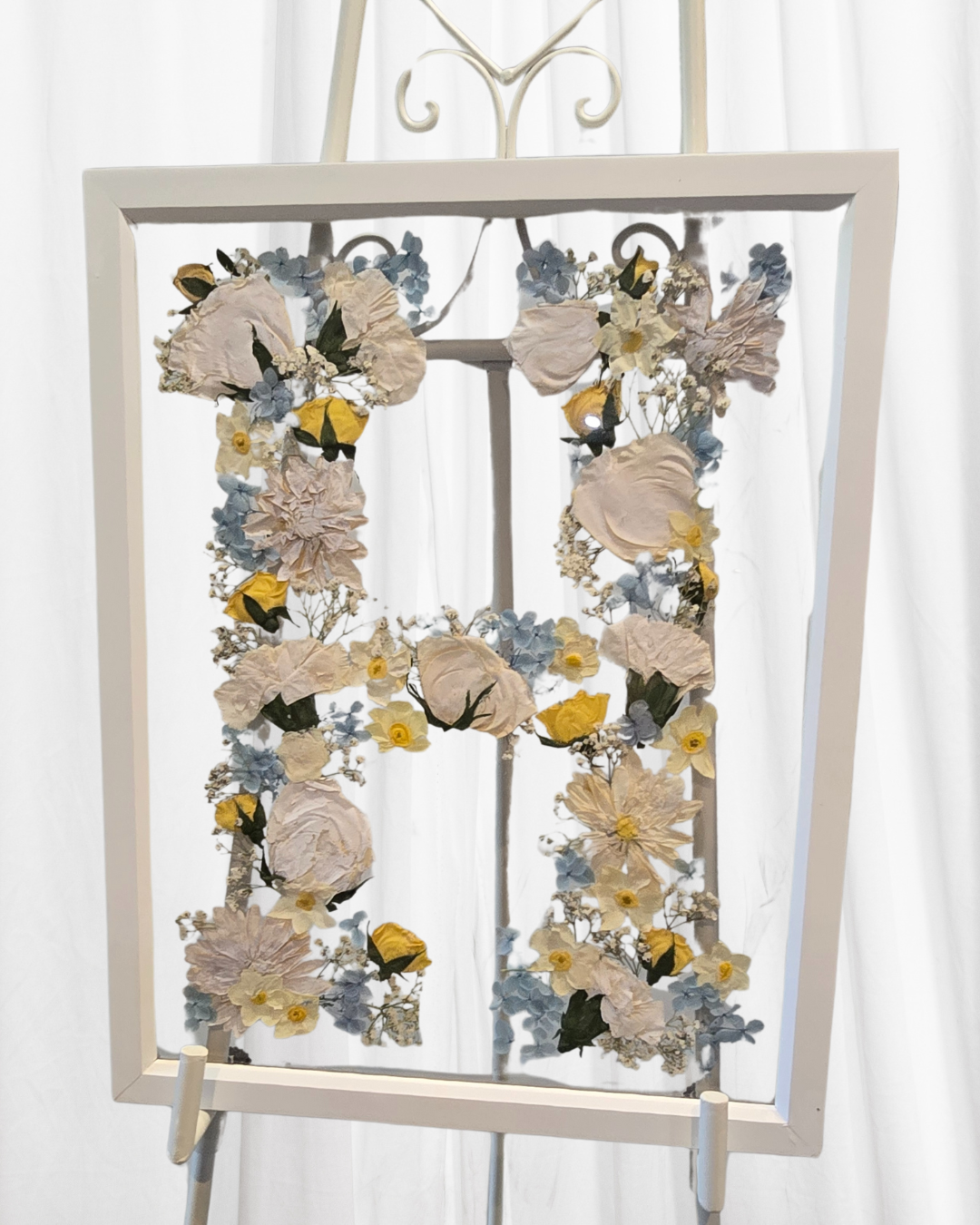 Funeral flowers pressed in glass frame.