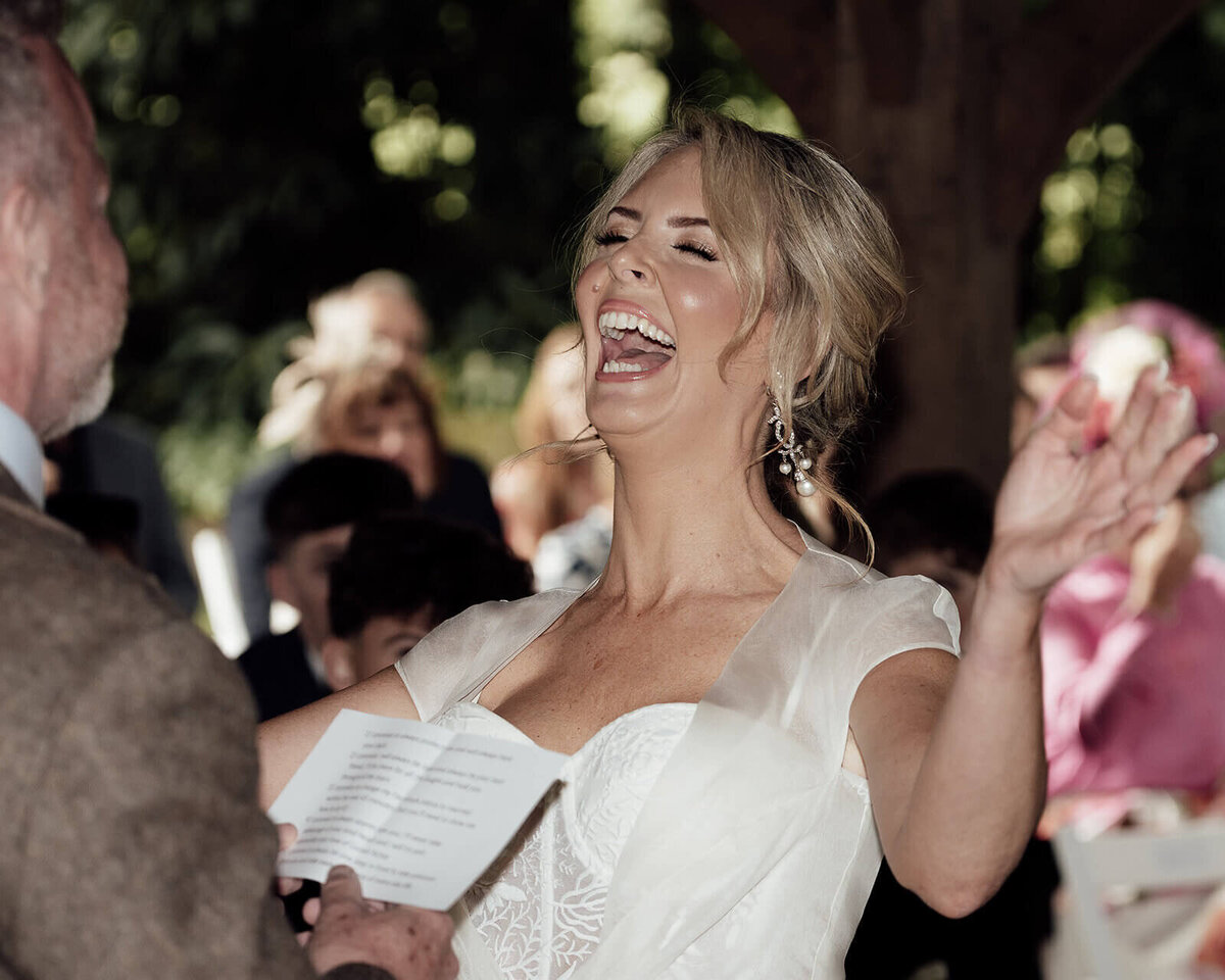 a bride belly laughs during her wedding service 